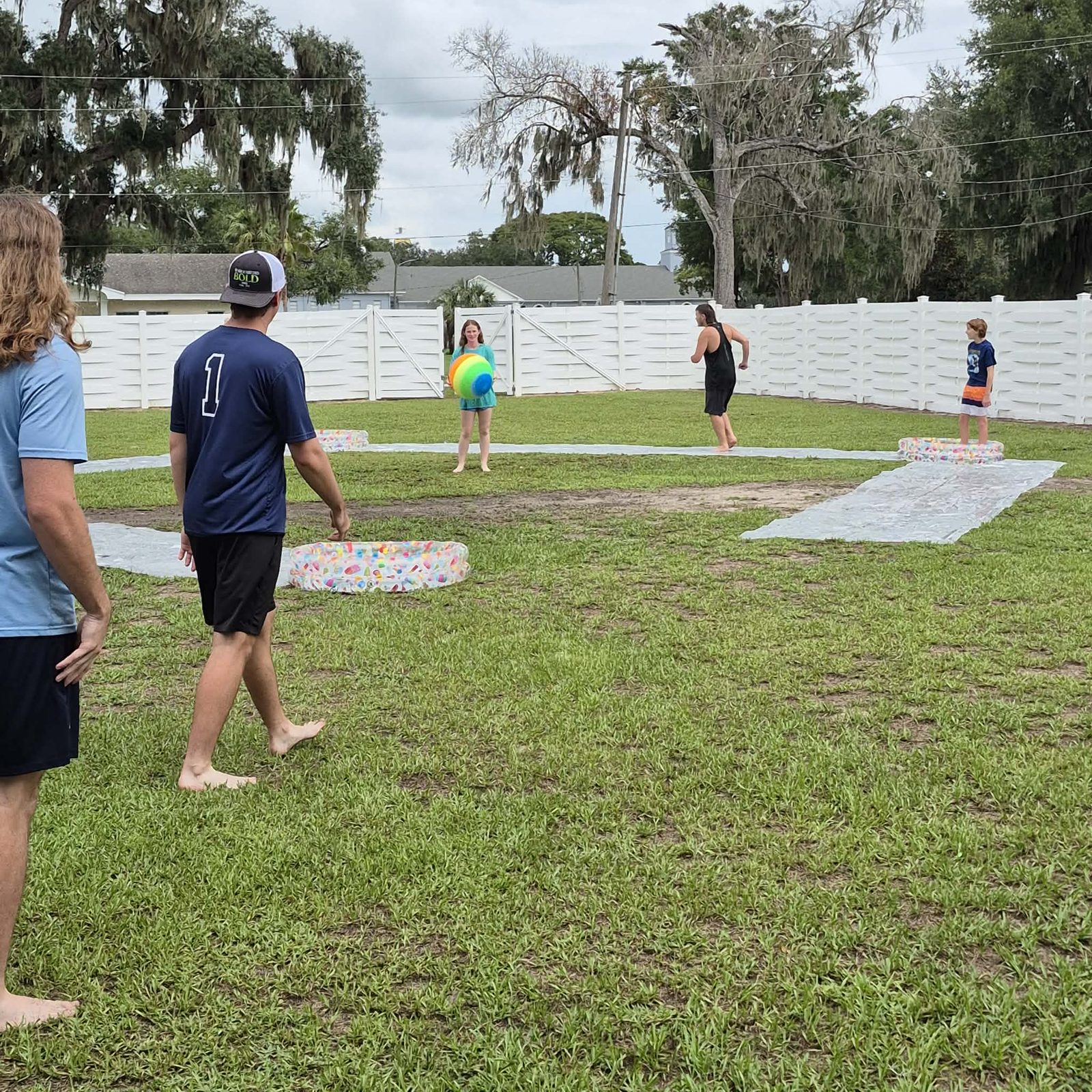 A group playing a water balloon slip and slide game during fun events