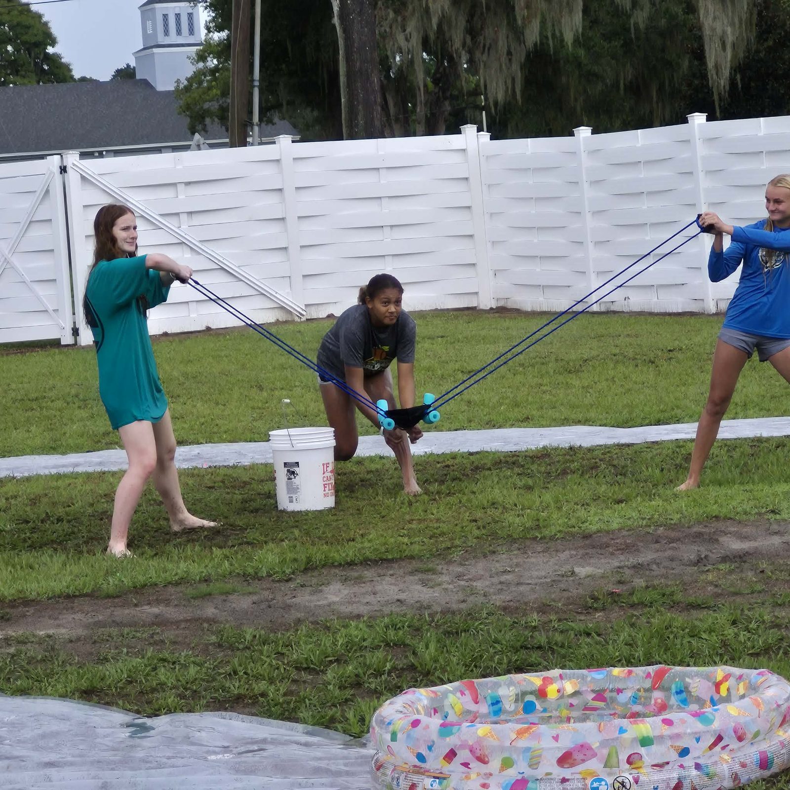 Students using a giant slingshot to launch a water balloon during a fun events game