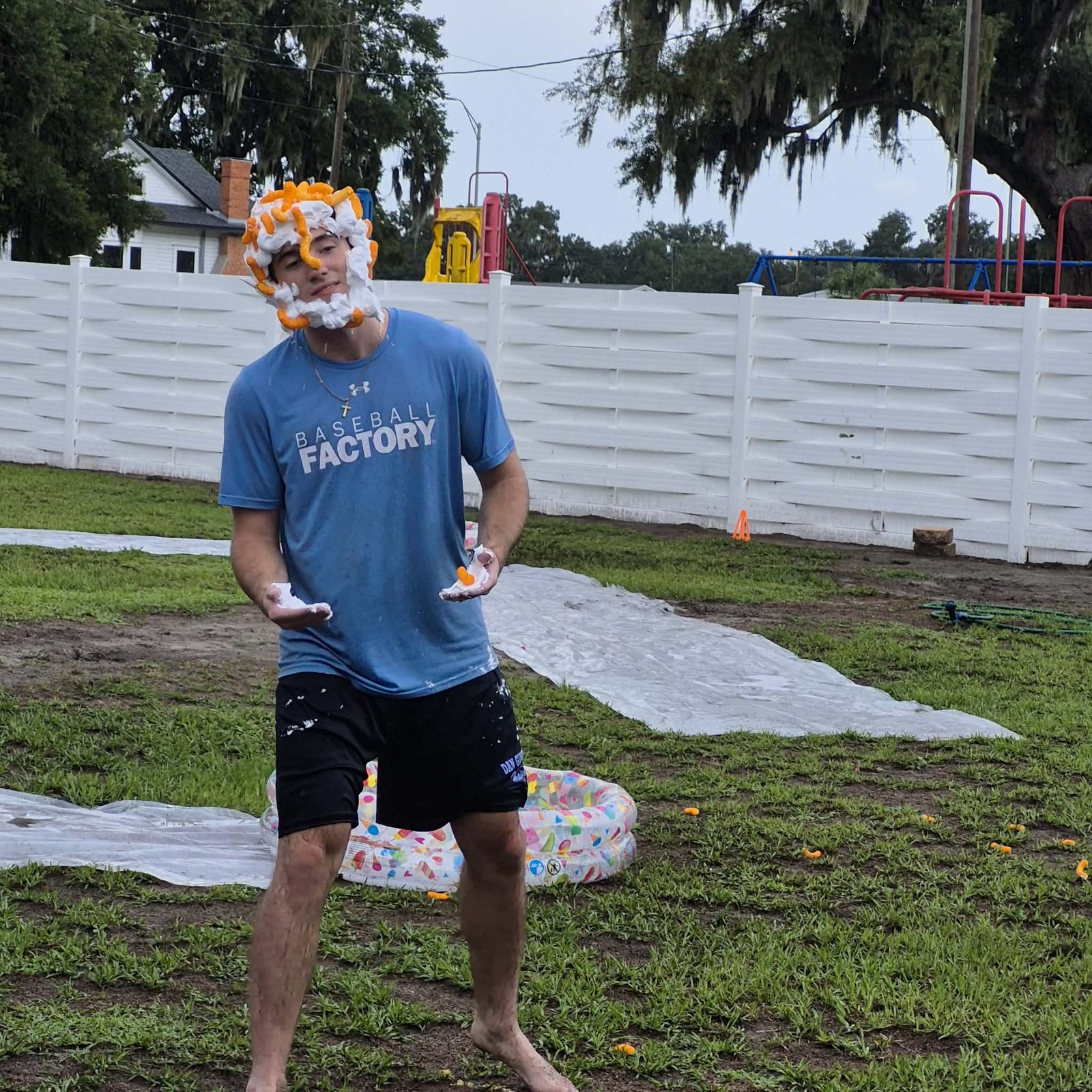 A student with shaving cream and cheese puffs on his face after a fun events game