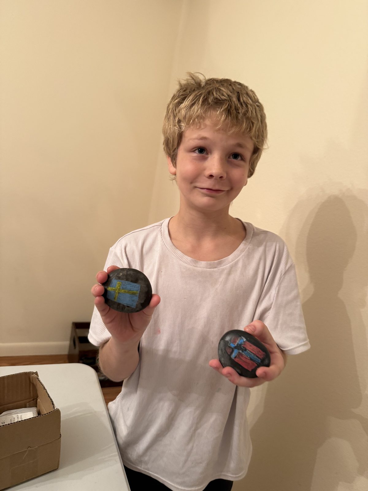 A student holding two hand-painted rocks during a fun events craft night