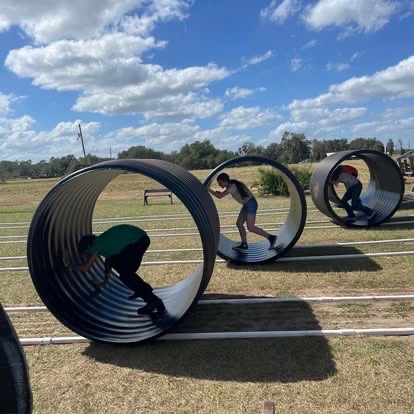 Students racing through large culvert tubes on game night