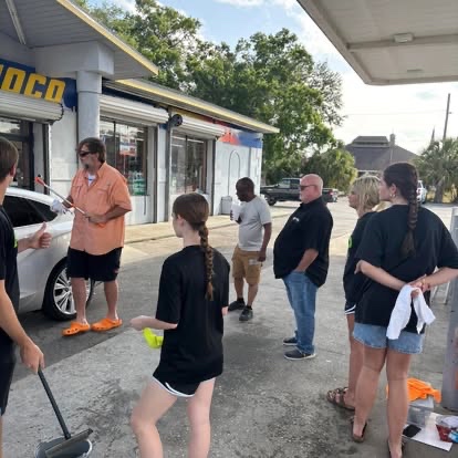 Students and volunteers gathered at a car wash service project