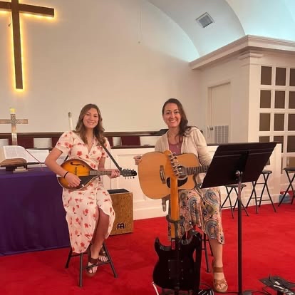 Two worship leaders playing mandolin and guitar during worship night