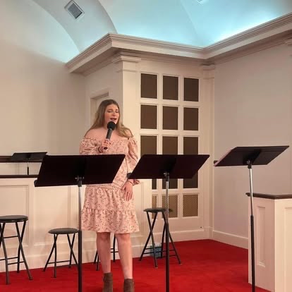 A student singing into a microphone during worship night